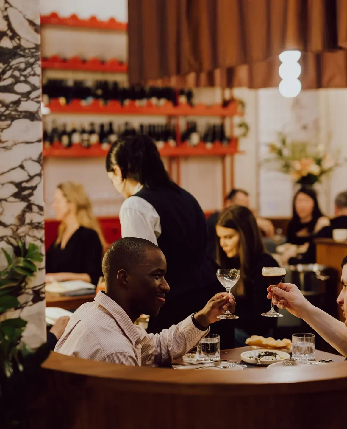 Cheers at Fugazzi restaurant in Adelaide: People toasting drinks with elegant interior.