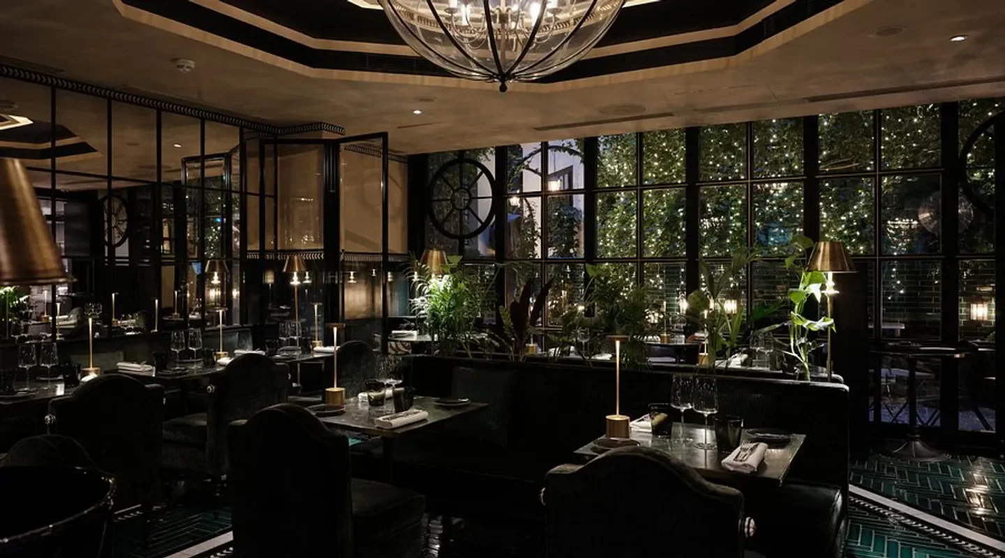 Elegant interior of Galanga restaurant in Paris, featuring dim lighting and lush greenery.