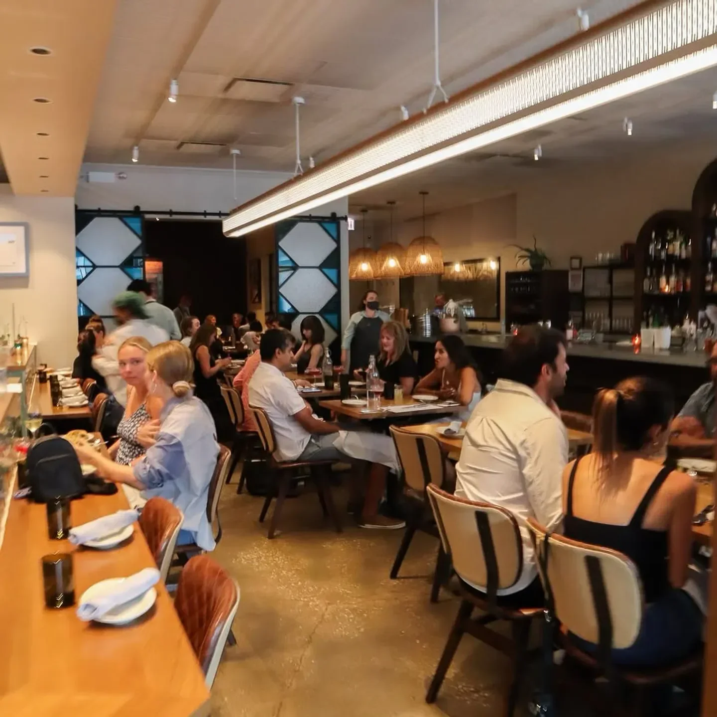 Busy dining room at Galit restaurant in Chicago with people enjoying meals.