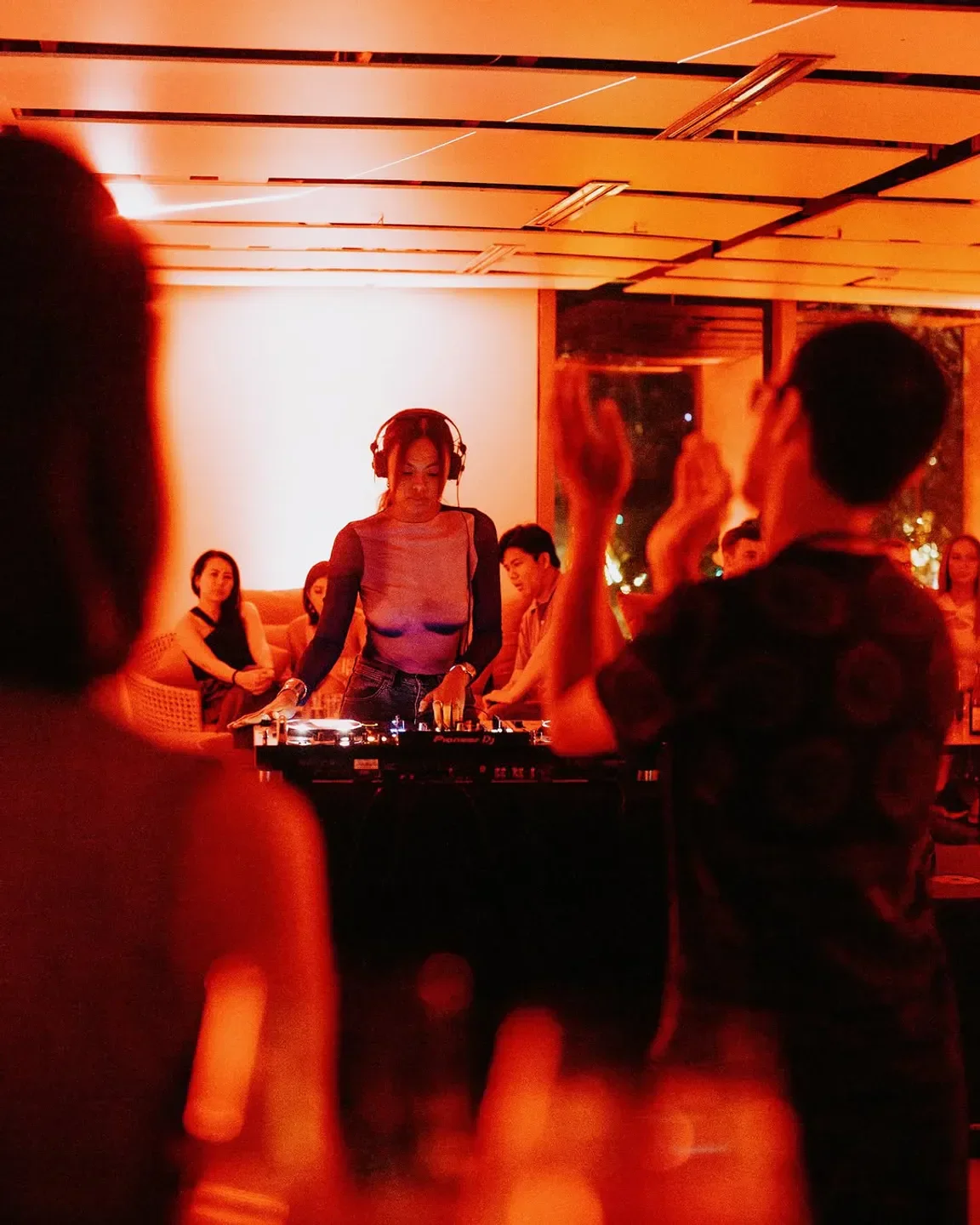 DJ at Gallery By Chele, Manila, playing music in a warmly lit, lively restaurant setting.