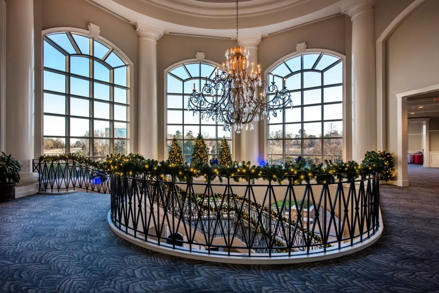 Elegant interior of Gallery Restaurant in Charlotte, featuring a grand staircase with holiday decor
