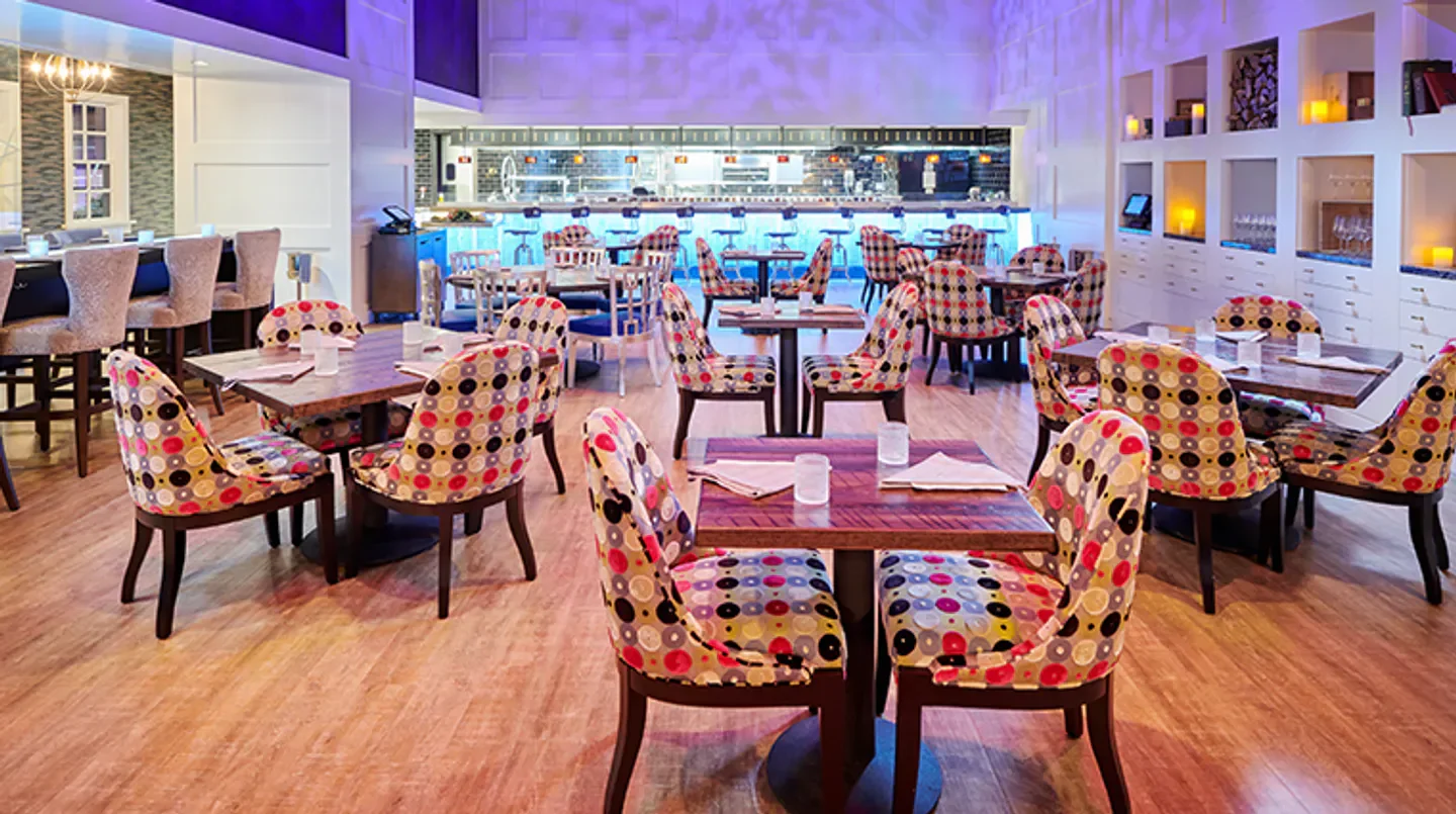 Interior dining area at Garrison restaurant in Austin, featuring patterned chairs and tables.