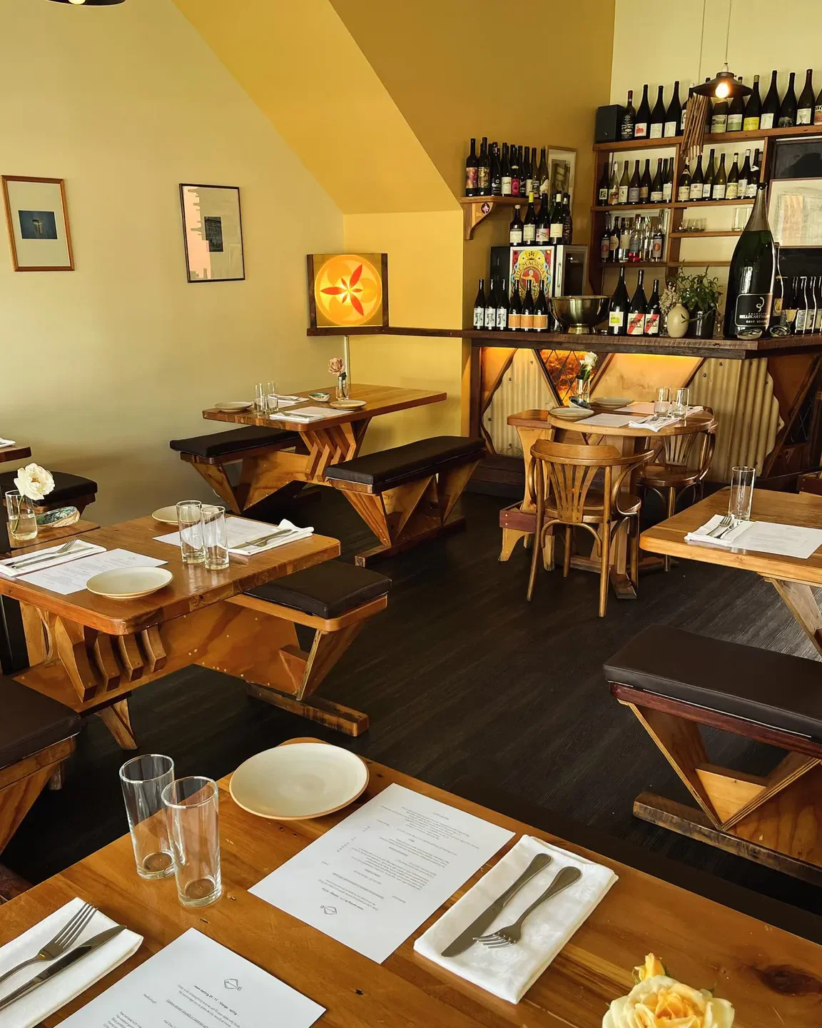 Interior of Gatherings restaurant in Christchurch, featuring wooden tables and a bar.