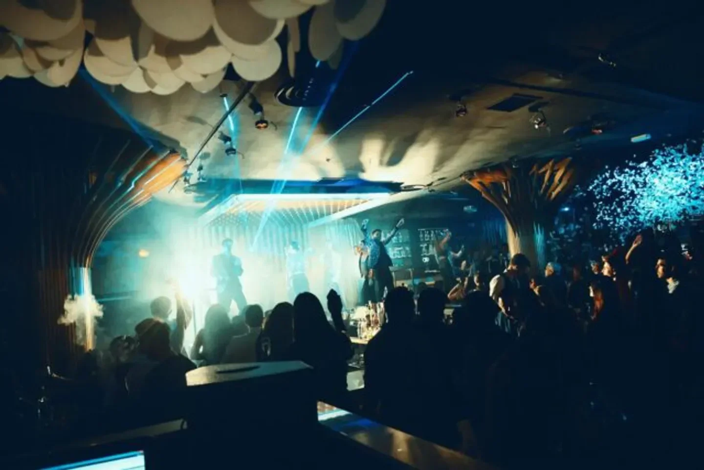 Energetic nightclub scene at Gatsby Barcelona, with performers and crowd under stage lights.