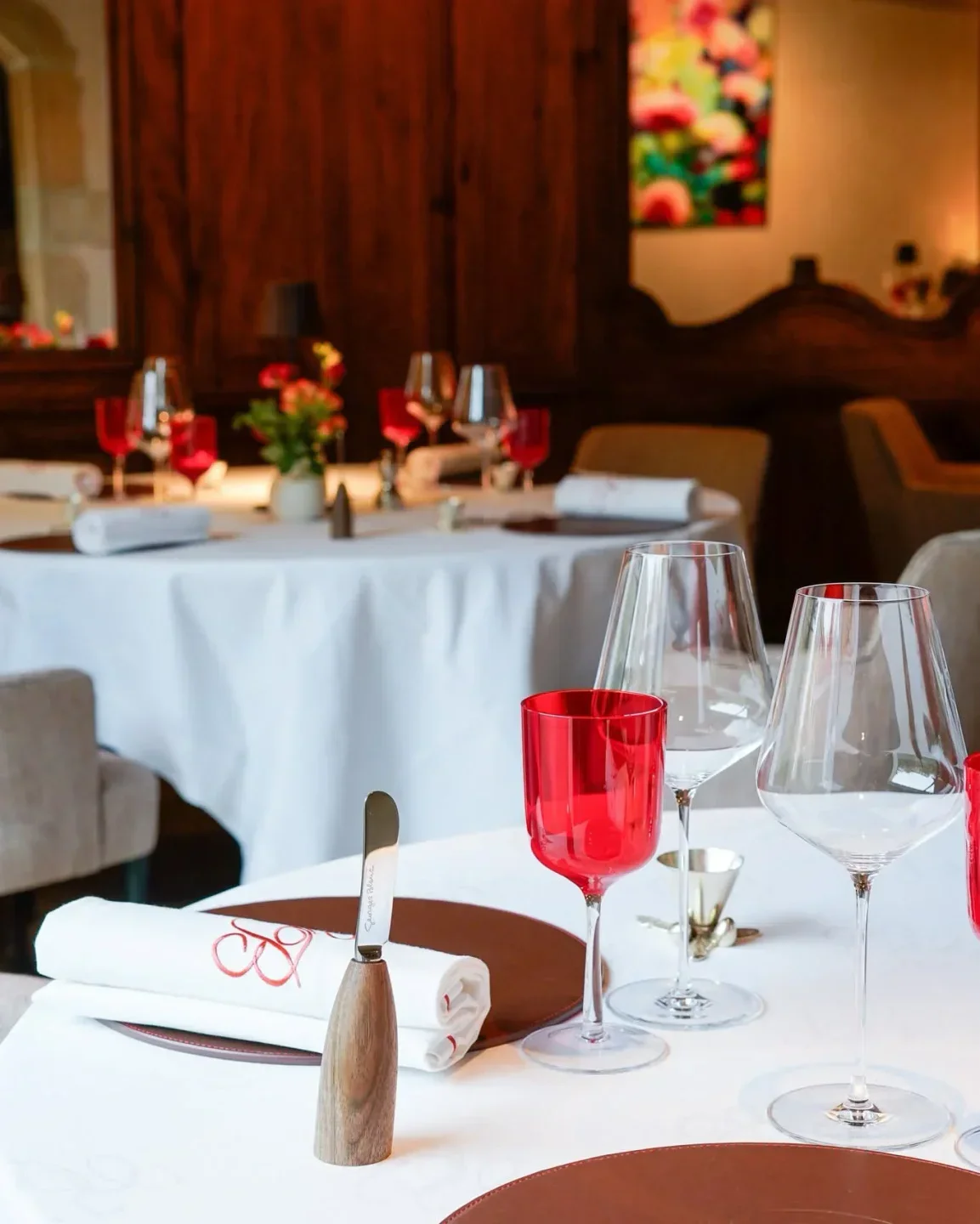 Elegant dining at Georges Blanc restaurant in Lyon, featuring red glasses and table settings.