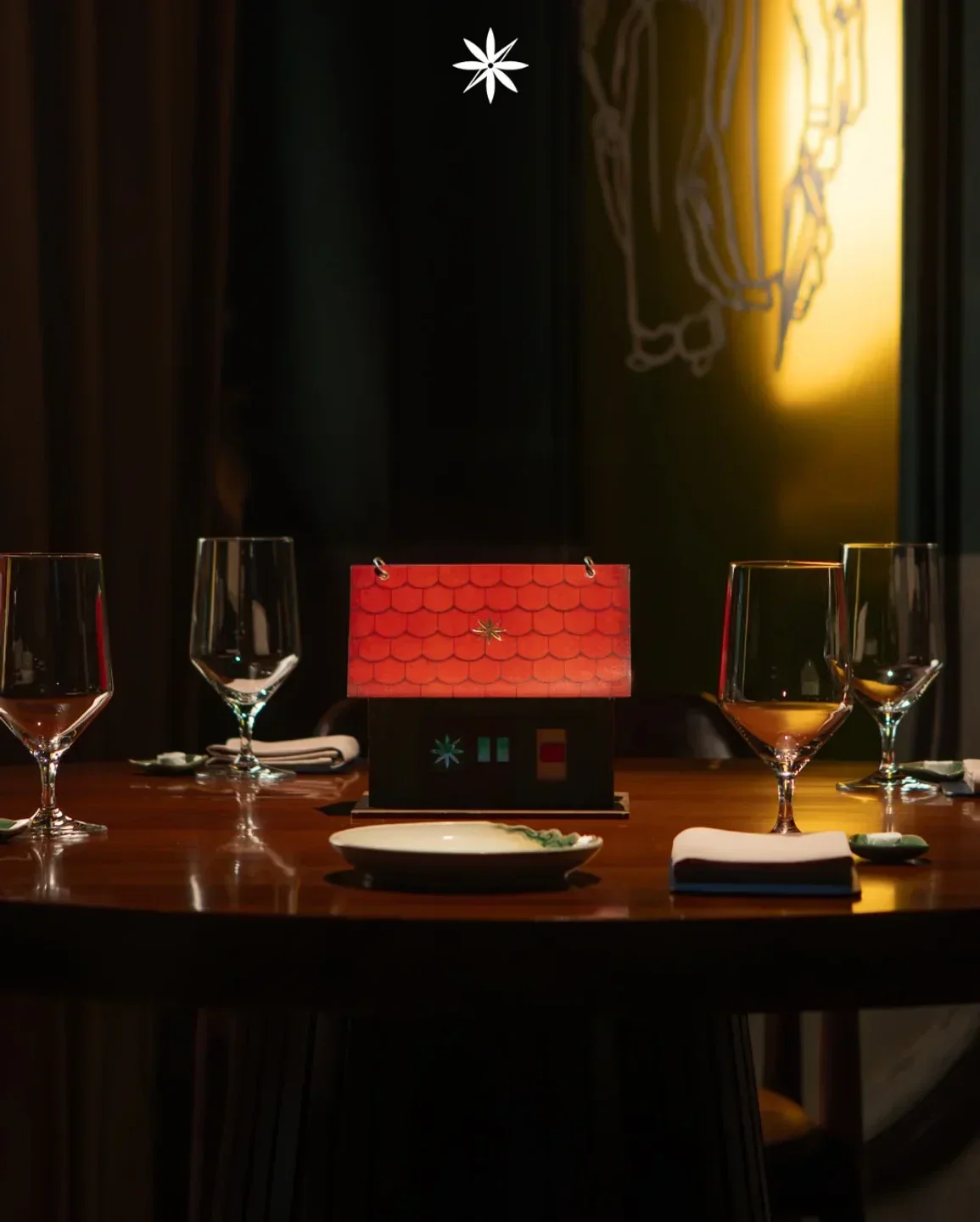 Table setting at Gia restaurant in Hanoi featuring a decorative house detail.
