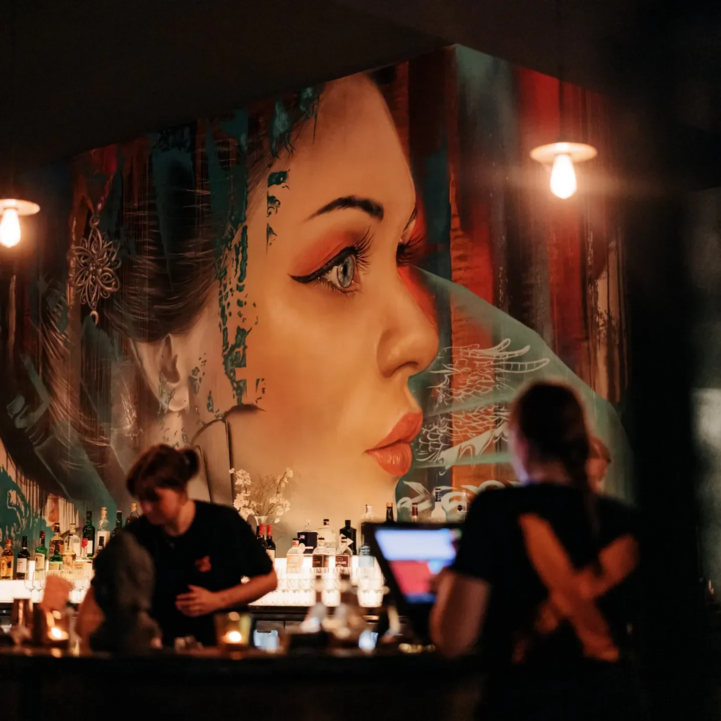 Interior of Ginger Meg's in Newcastle, featuring a large mural and bar staff.