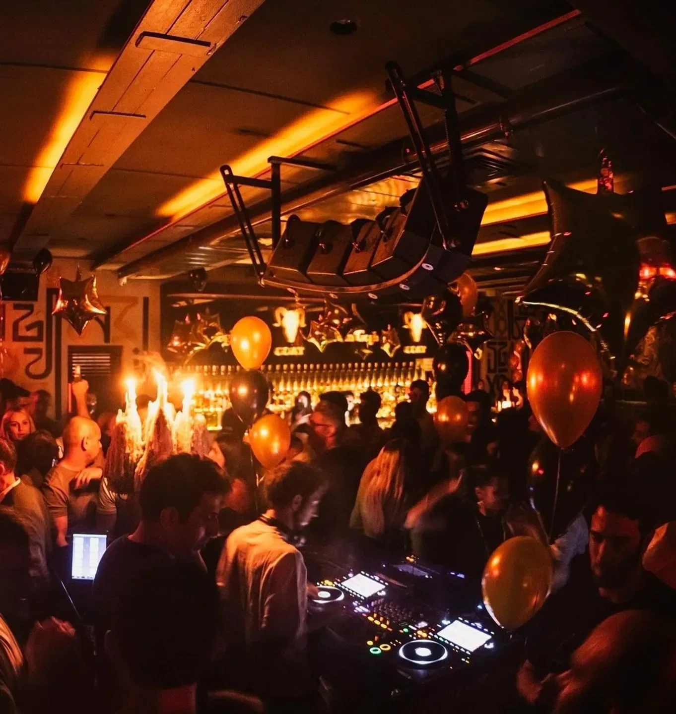 Inside GOAT nightclub in Tel Aviv with DJs, balloons, and a lively party atmosphere.