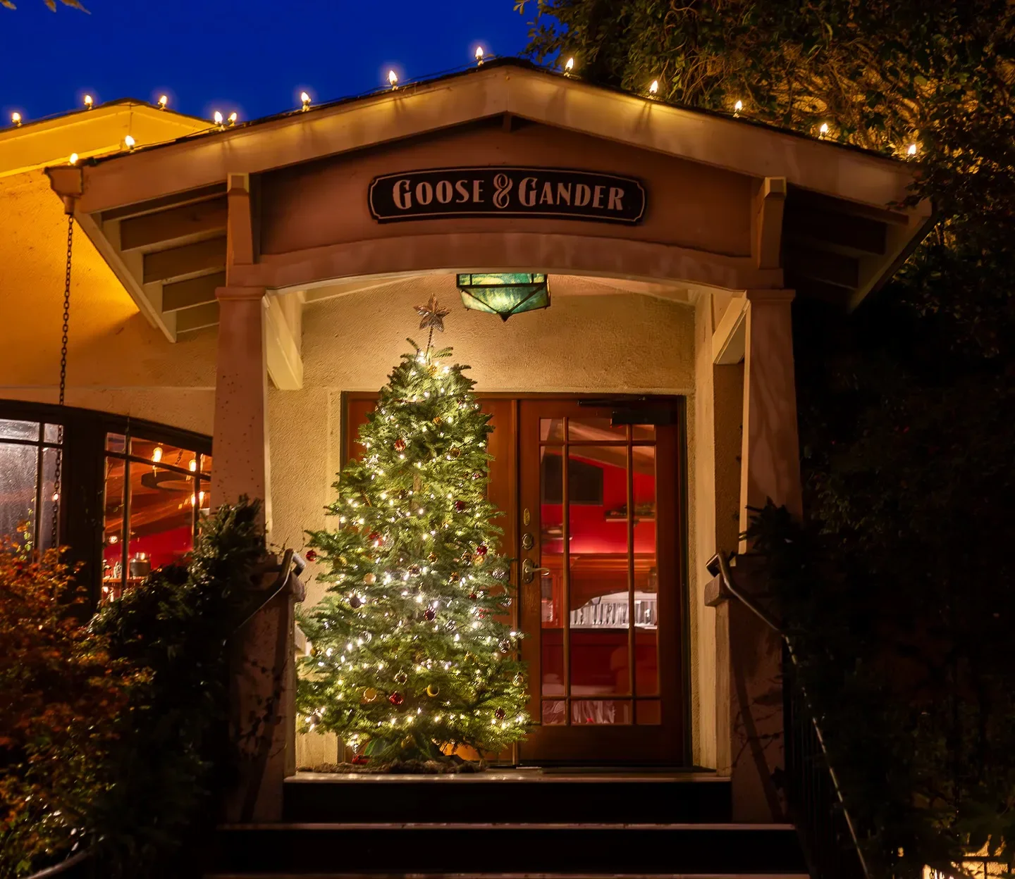 Festive entrance of Goose & Gander restaurant in Napa Valley, adorned with a Christmas tree