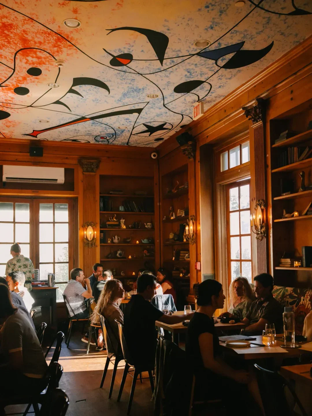 Interior of Goosefeather restaurant in the Hudson Valley with patrons dining under a painted ceiling.