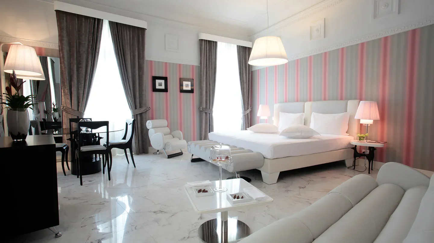 Elegant bedroom at the Grand Hotel Palace in Rome, featuring stylish decor and luxurious comfort.