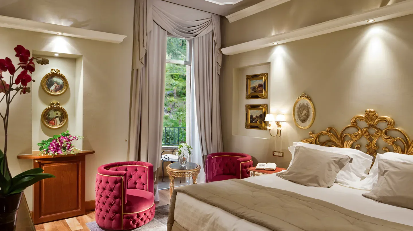 Elegant room at Grand Hotel Tremezzo in Rome, with stylish chairs and ornate bed.