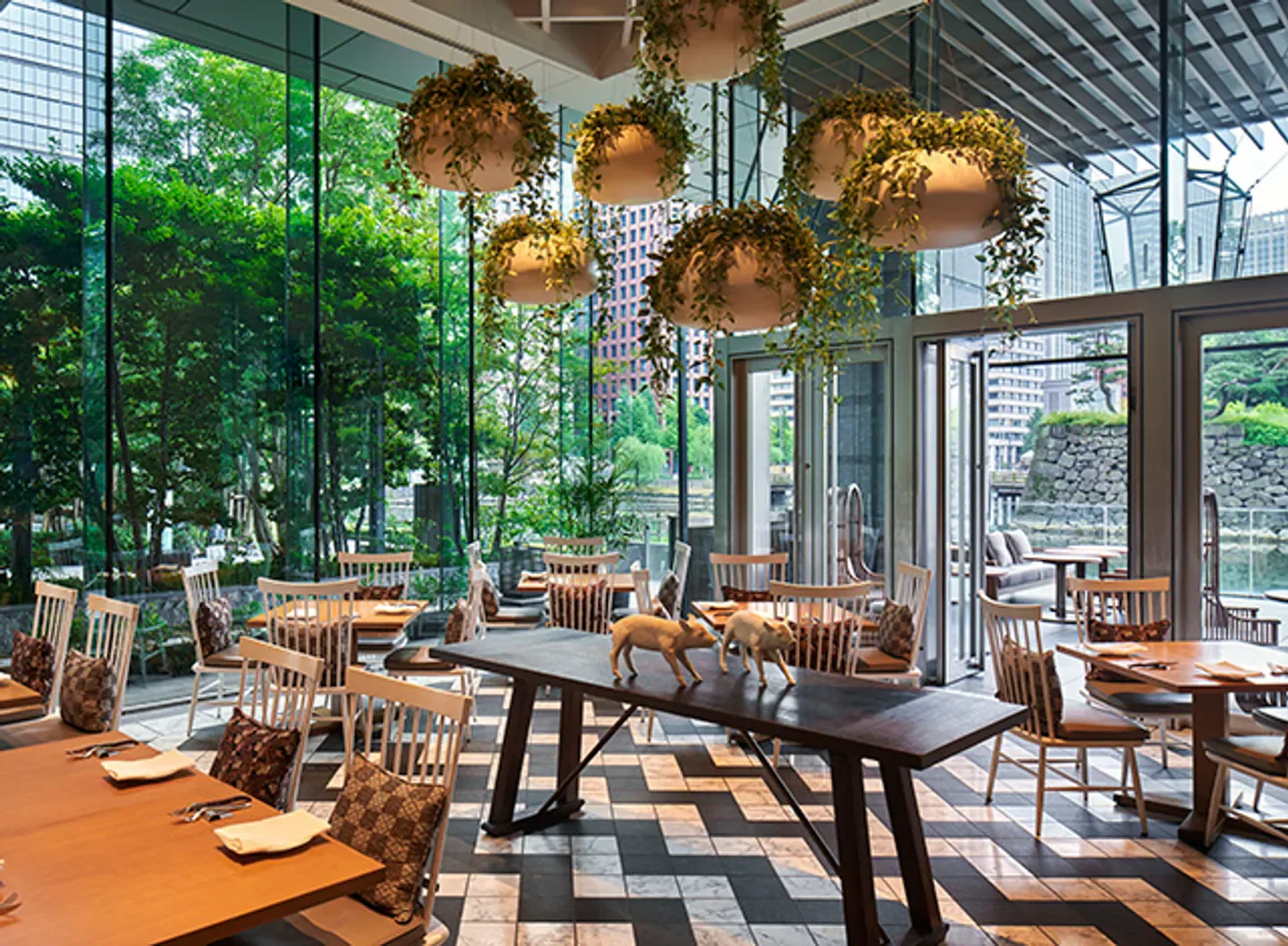 Elegant dining at Grand Kitchen in Tokyo with hanging plants and natural light.