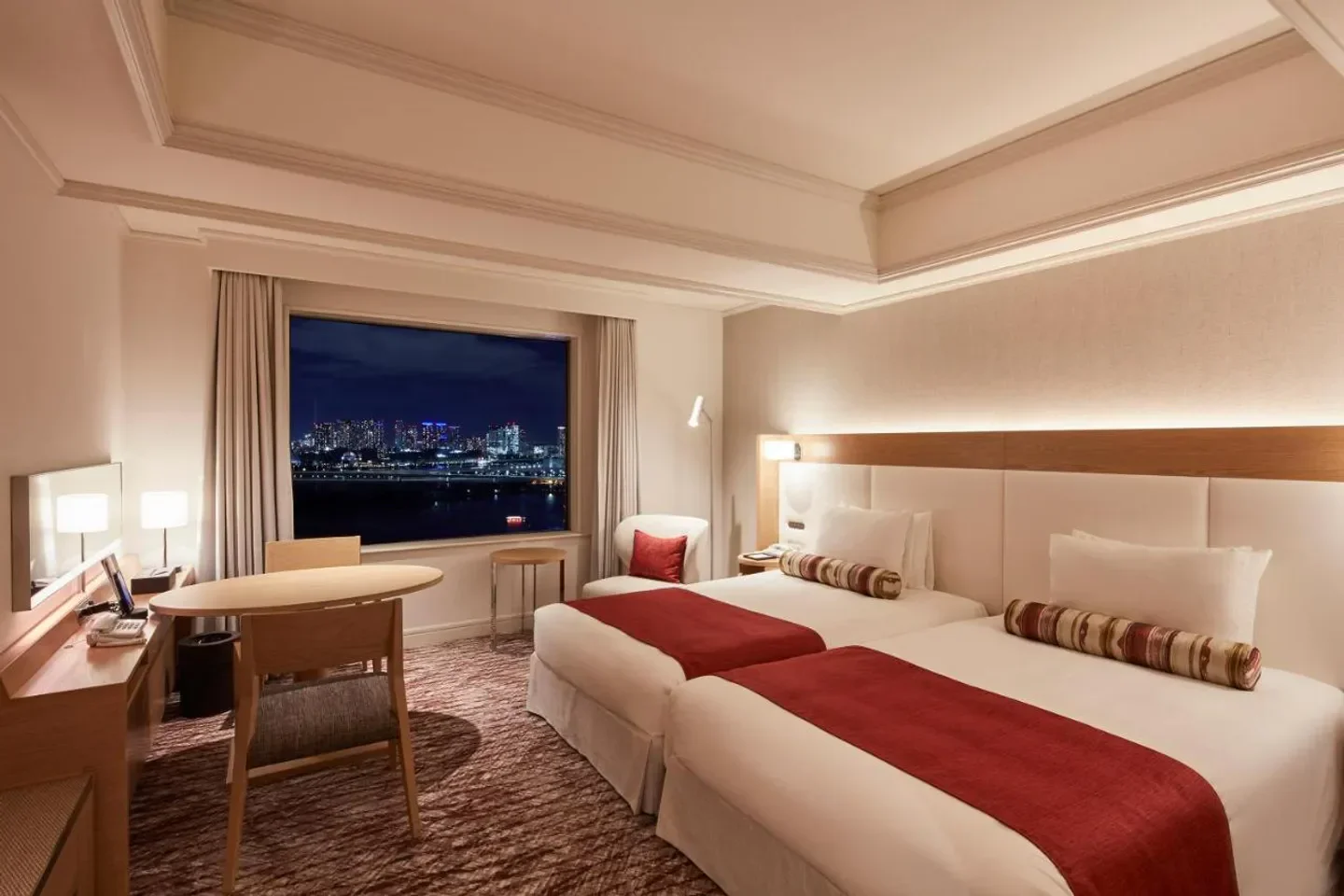 Cozy bedroom at Grand Nikko Tokyo Daiba with Tokyo skyline view at night.
