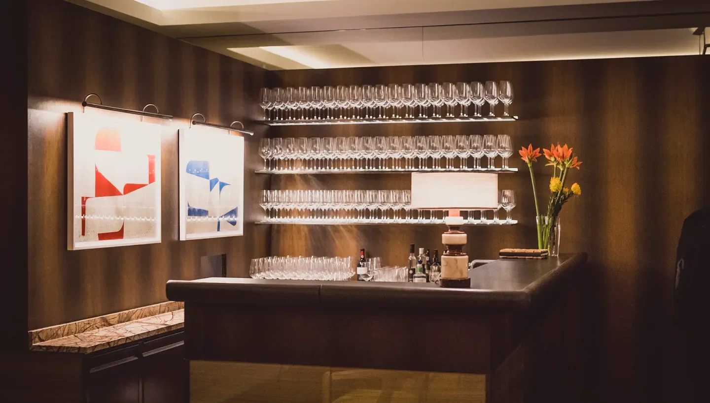 Elegant bar interior at Grapes Weinbar, Munich, with art, glassware, and flowers