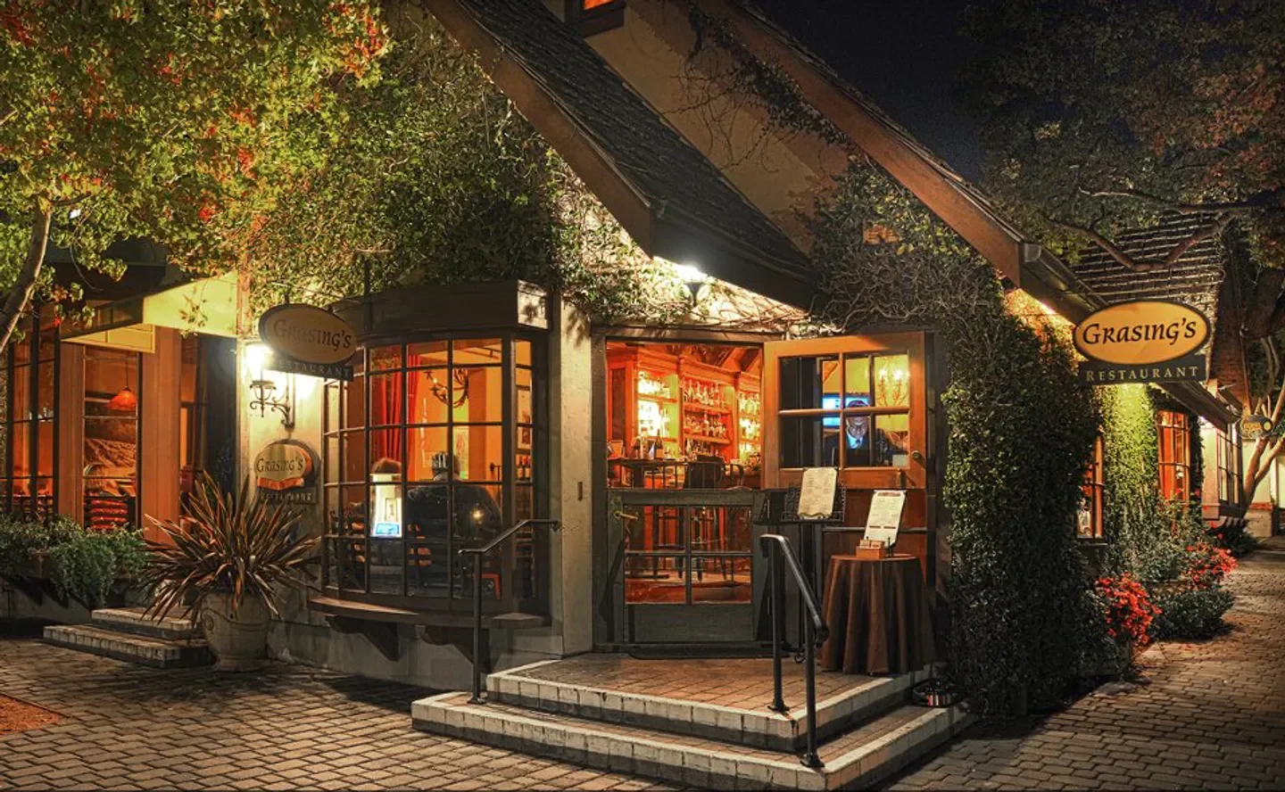 Exterior view of Grasings restaurant in Carmel, with inviting lights and entrance at night