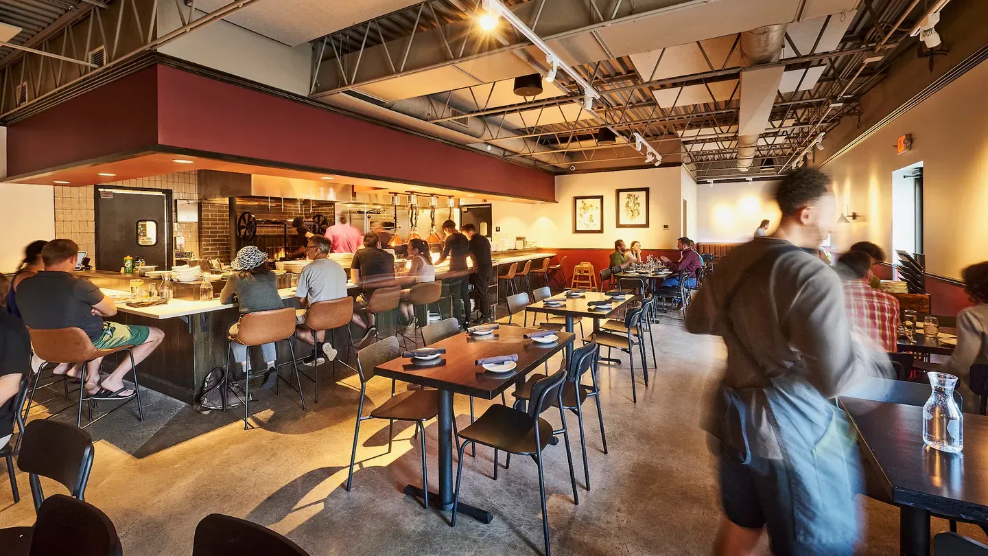 Interior of Gray Duck Tavern in Minneapolis, bar seating with patrons, dining tables.