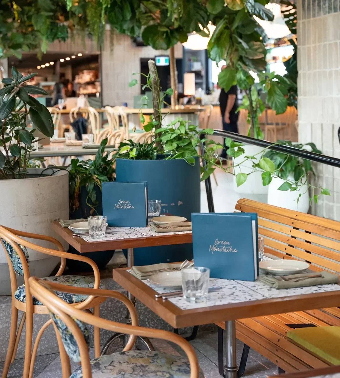 Cozy dining area at Green Moustache restaurant in Sydney with stylish decor and plants.