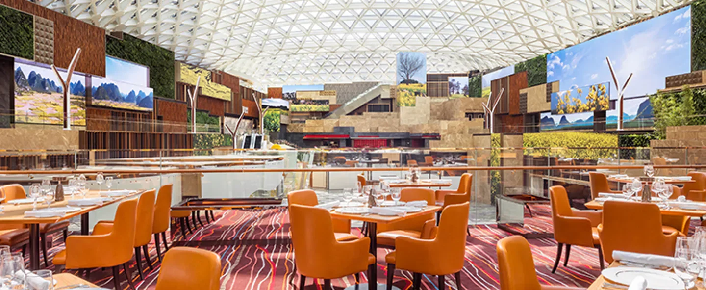 Interior of Grill 58 restaurant in Macau with scenic wall and elegant seating.