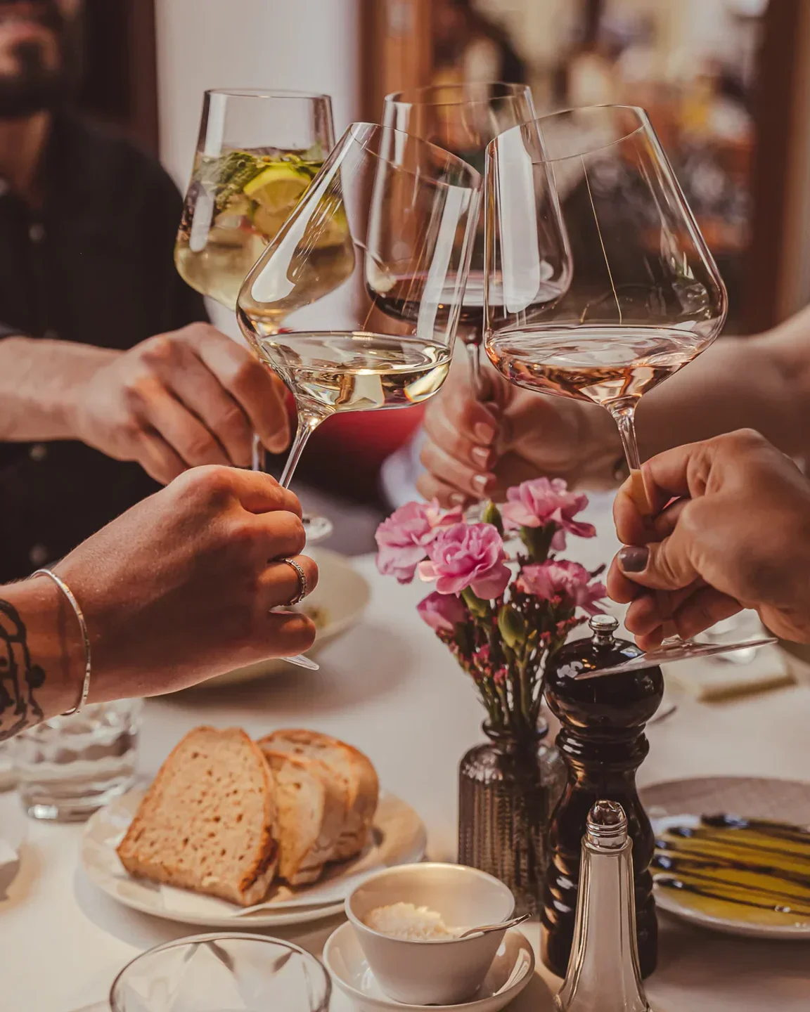 Cheers at Guido Al Duomo in Munich, with wine glasses and elegant dining.