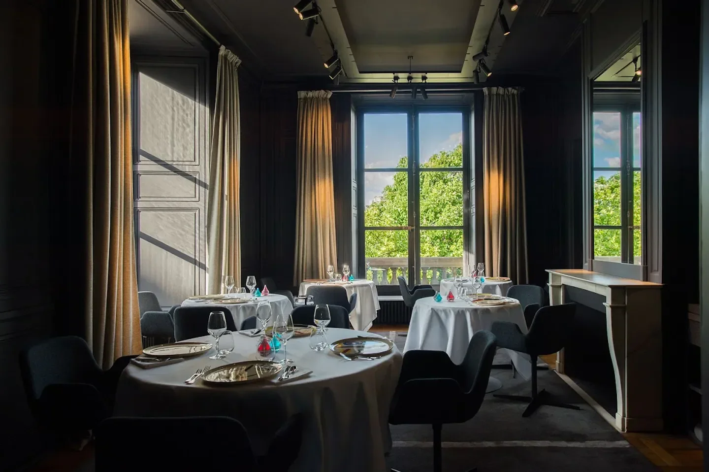 Elegant dining room at Guy Savoy in Paris, with tables set by a bright window