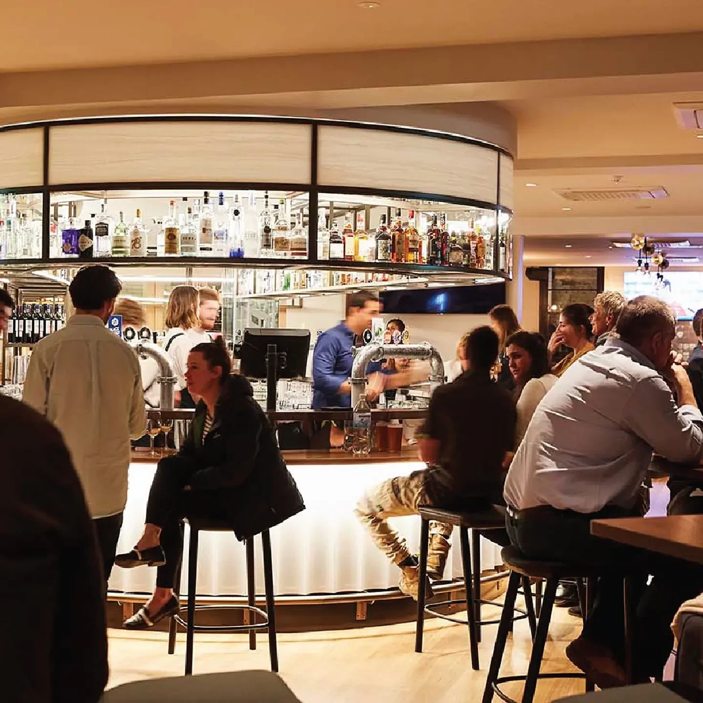 Busy bar at Hardimans restaurant in Melbourne, with customers and a well-stocked bar.