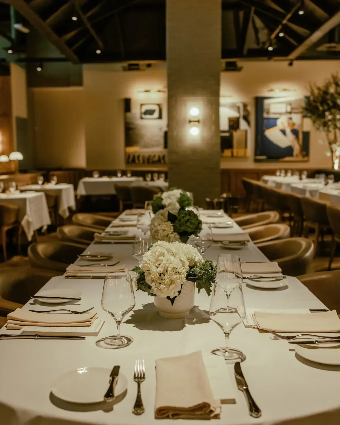 Elegant dining room at Harlo Steakhouse & Bar in Las Vegas, featuring floral centerpieces.