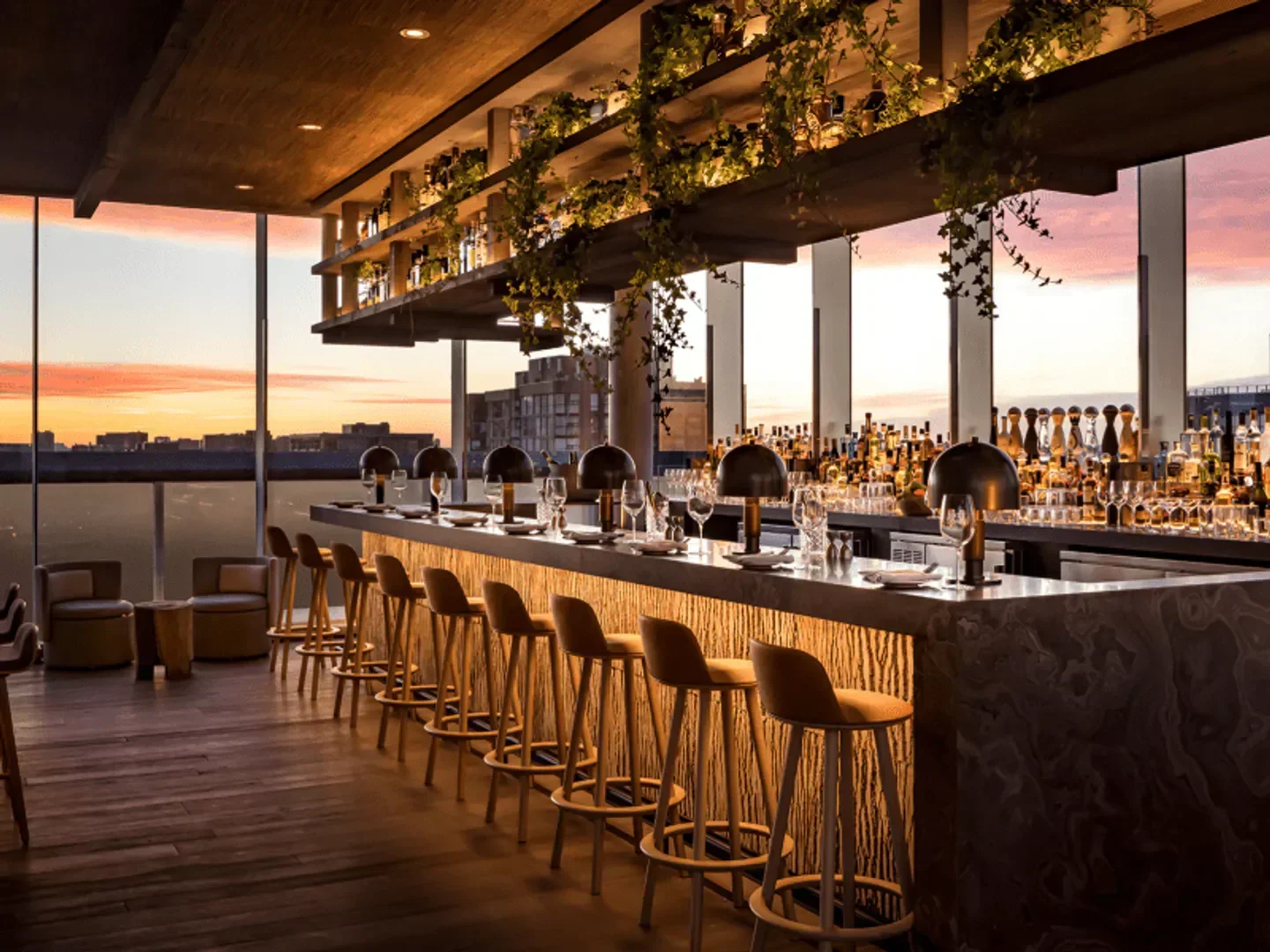 Stylish interior of Harriet's Rooftop bar in Toronto, with sunset views and bar stools.