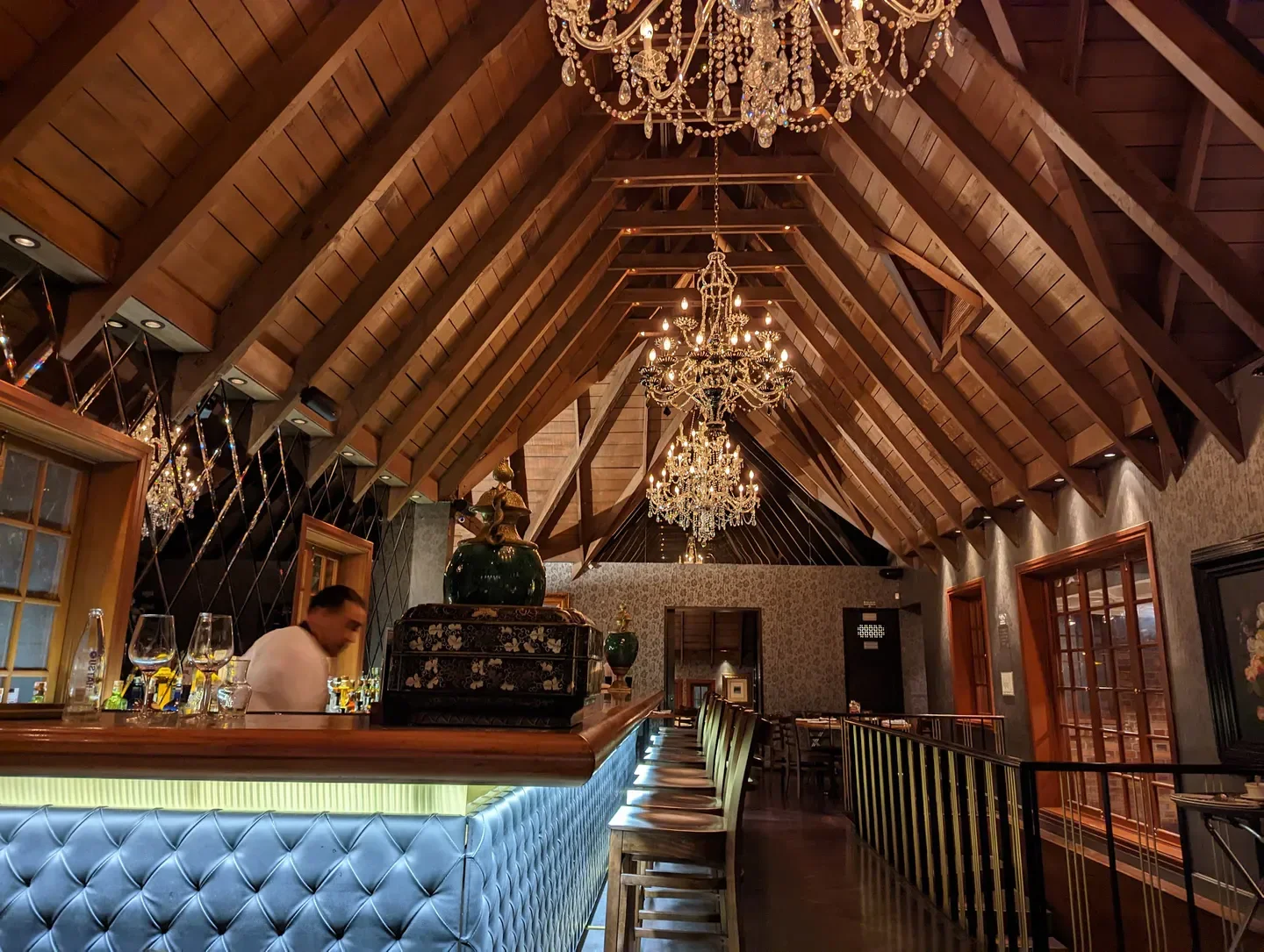 Interior of Harry Sasson restaurant in Bogota, featuring chandeliers and wooden beams.