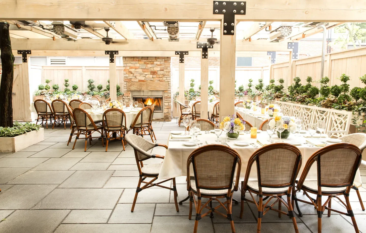 Outdoor patio at Harvest restaurant in Boston with fireplace and elegant table settings.