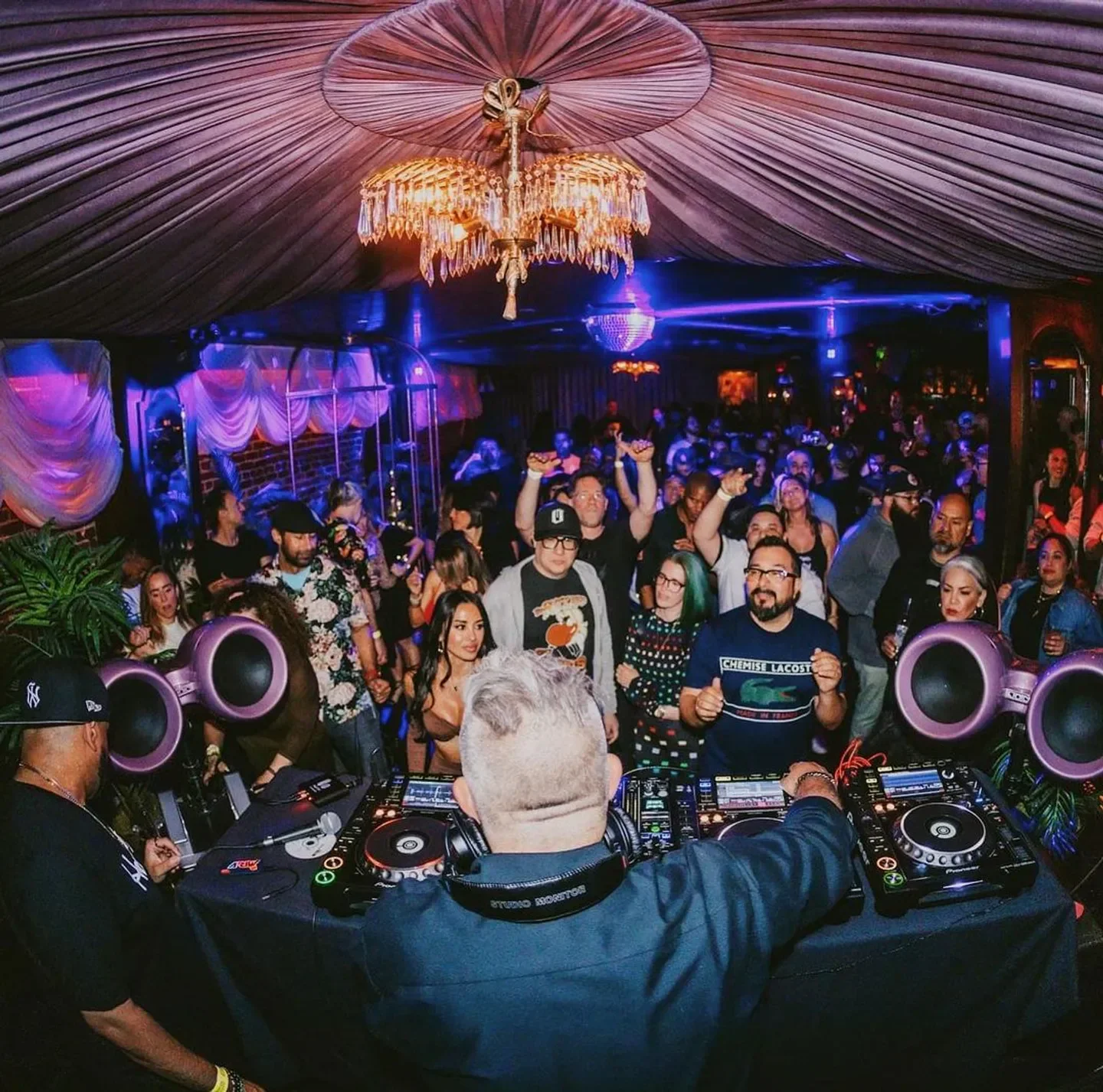 Energetic crowd dancing at Hawthorn nightclub in San Francisco with DJ playing music.