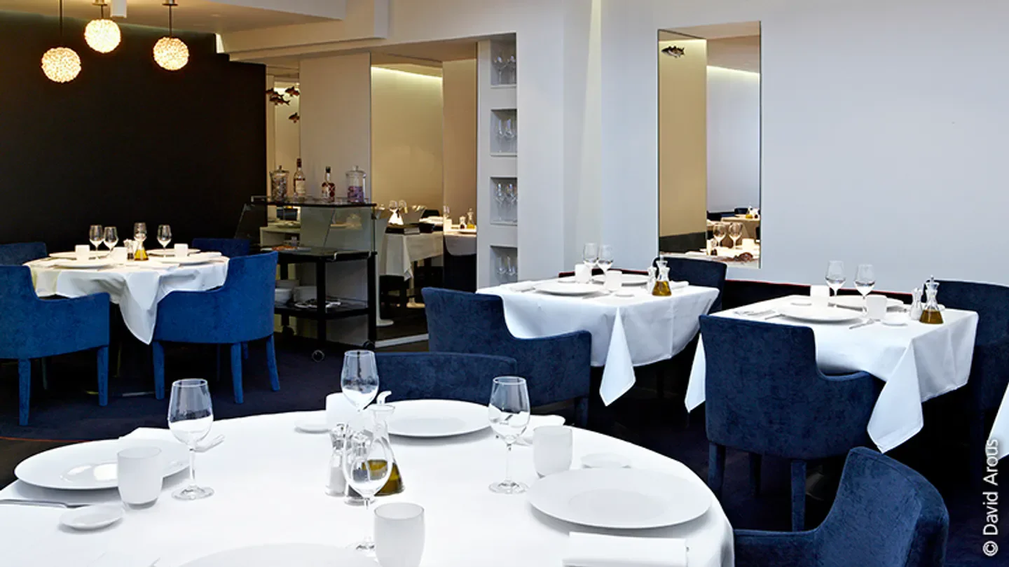 Elegant dining room at Helen restaurant in Paris with tables set for service