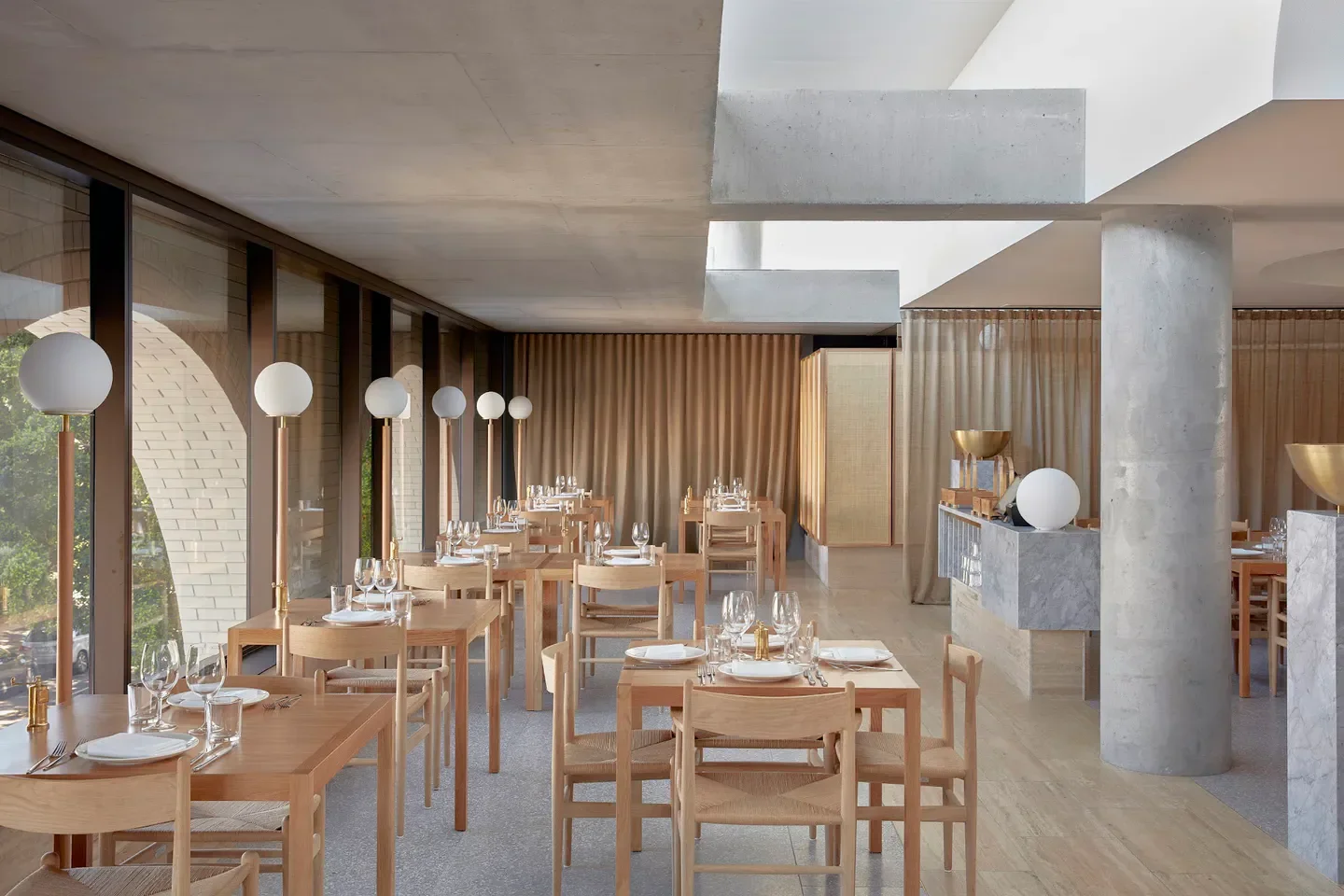 Inside Hellenika restaurant in Brisbane: minimalist design with natural light and elegant setting.