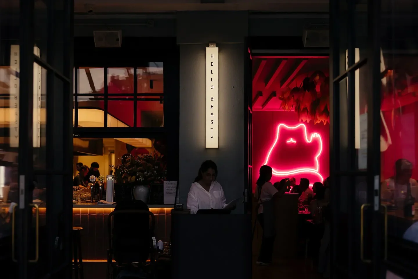 Entrance view of Hello Beasty restaurant in Auckland, with neon cat sign and decor.