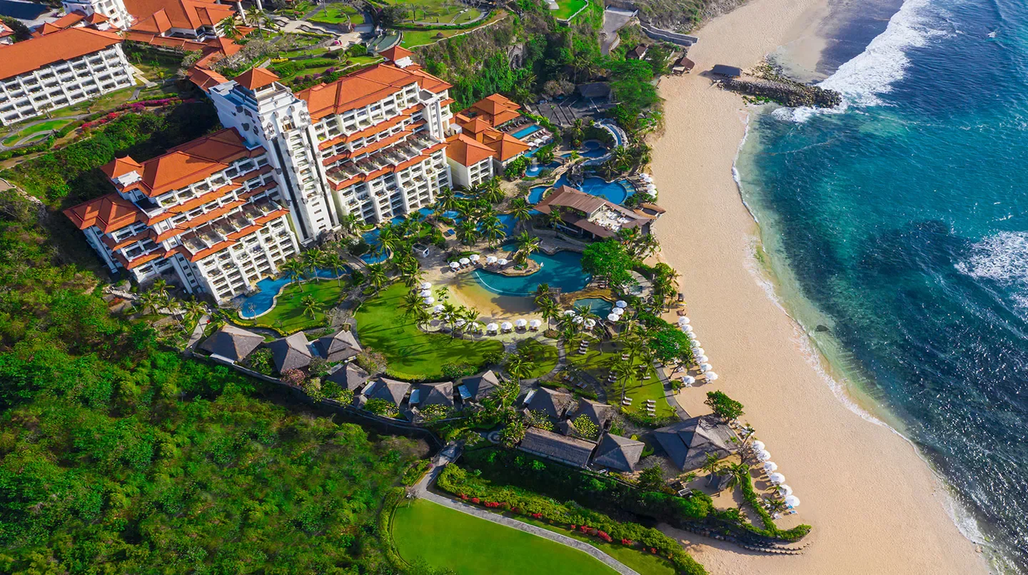 Aerial view of Hilton Bali Resort, featuring pools, beach, and beautiful scenery in Bali.