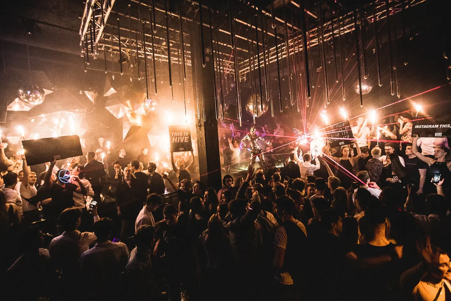 Energetic crowd at HIVE nightclub in Copenhagen, enjoying the party with lights and signs.