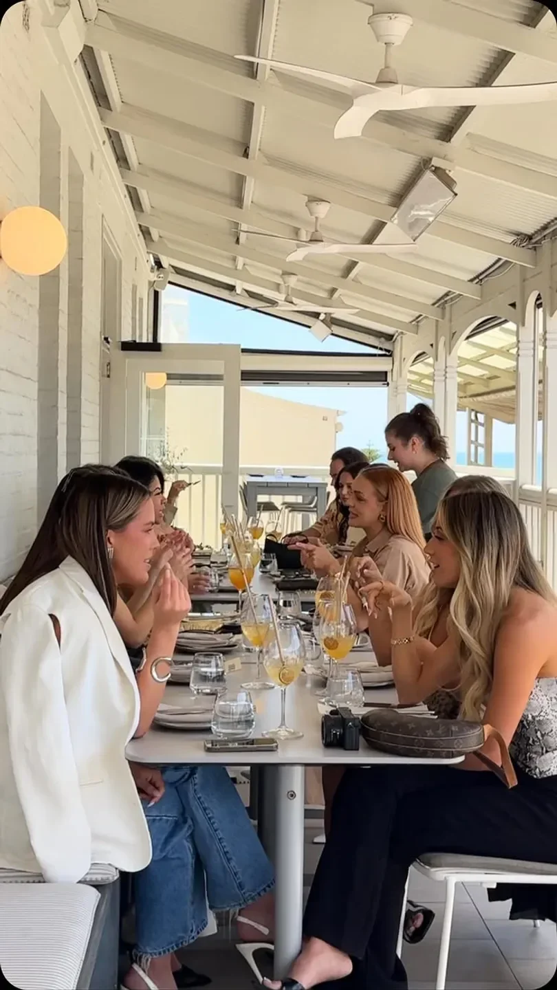 Group of friends dining at HNLY restaurant in Adelaide, enjoying drinks and meals.