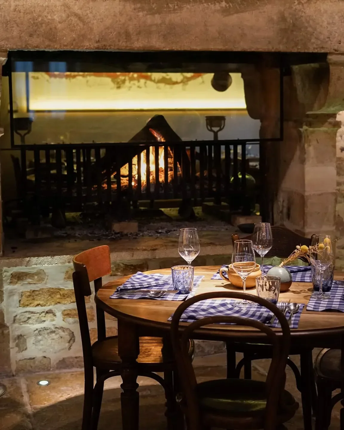 Cozy dining at Hostellerie de Levernois restaurant in Bourgogne, with a fireplace in background