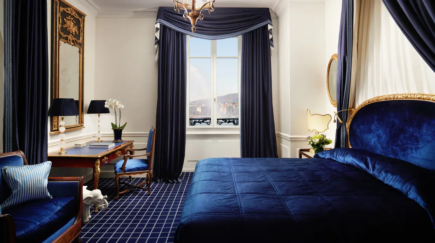 Elegant hotel room at Hotel d'Angleterre in Geneva with blue decor and city view
