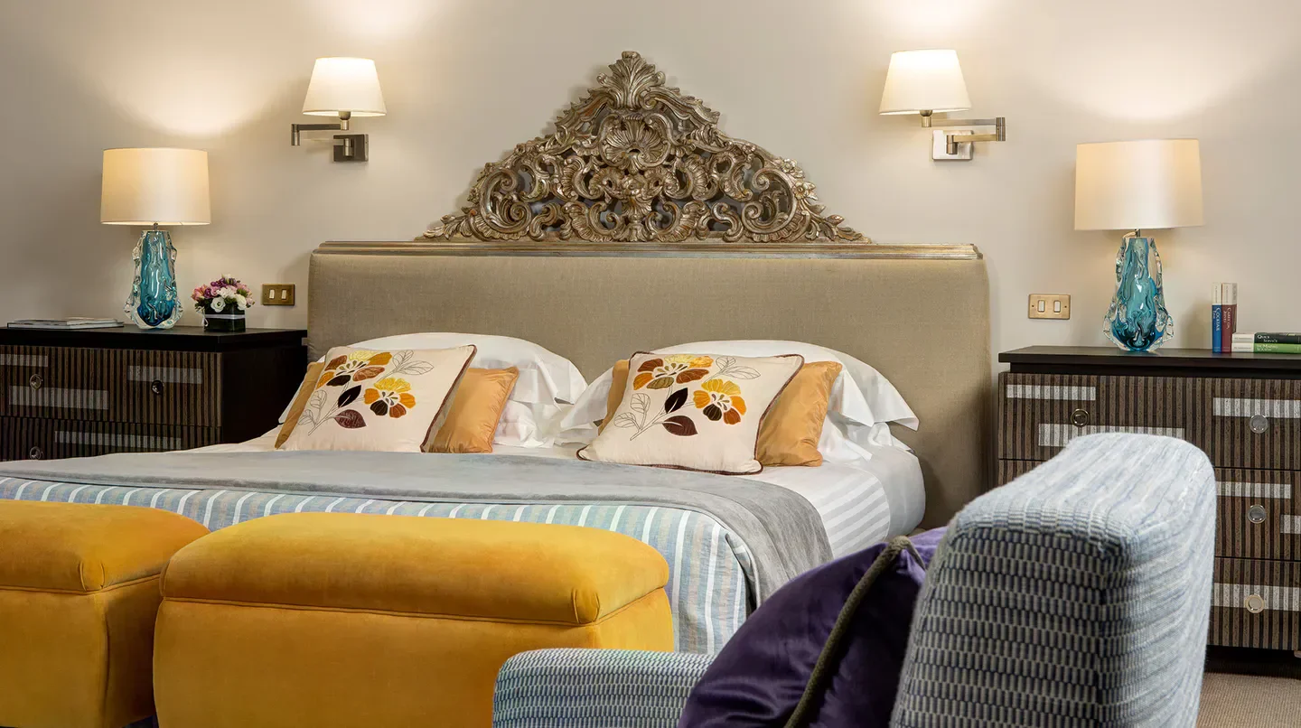 Luxury bedroom at Hotel de Russie, a Rocco Forte Hotel, Rome with ornate headboard.