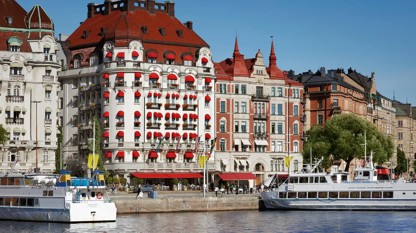 Hotel Diplomat Stockholm waterfront view with boats and historic architecture.