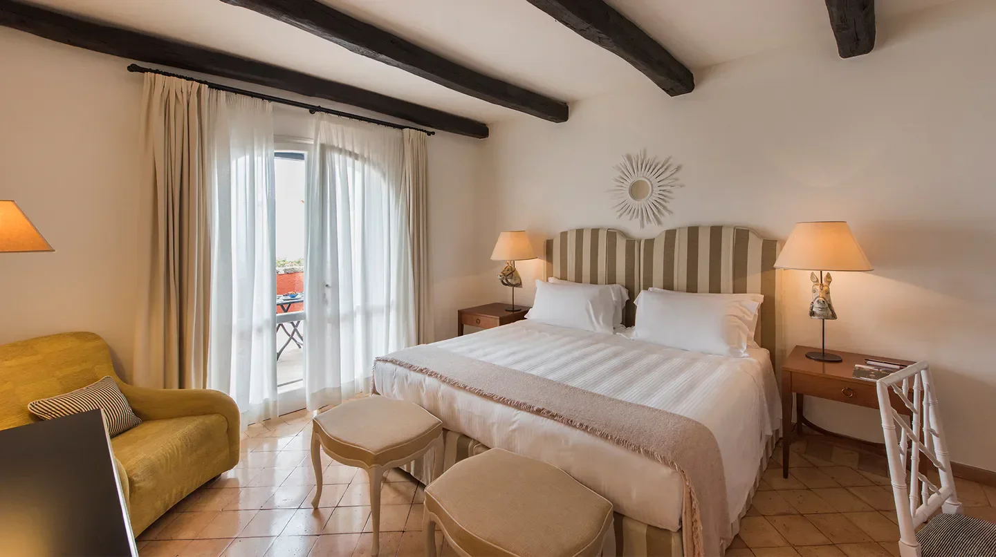 Cozy bedroom at Hotel Il Pellicano in Florence, featuring a balcony and elegant decor