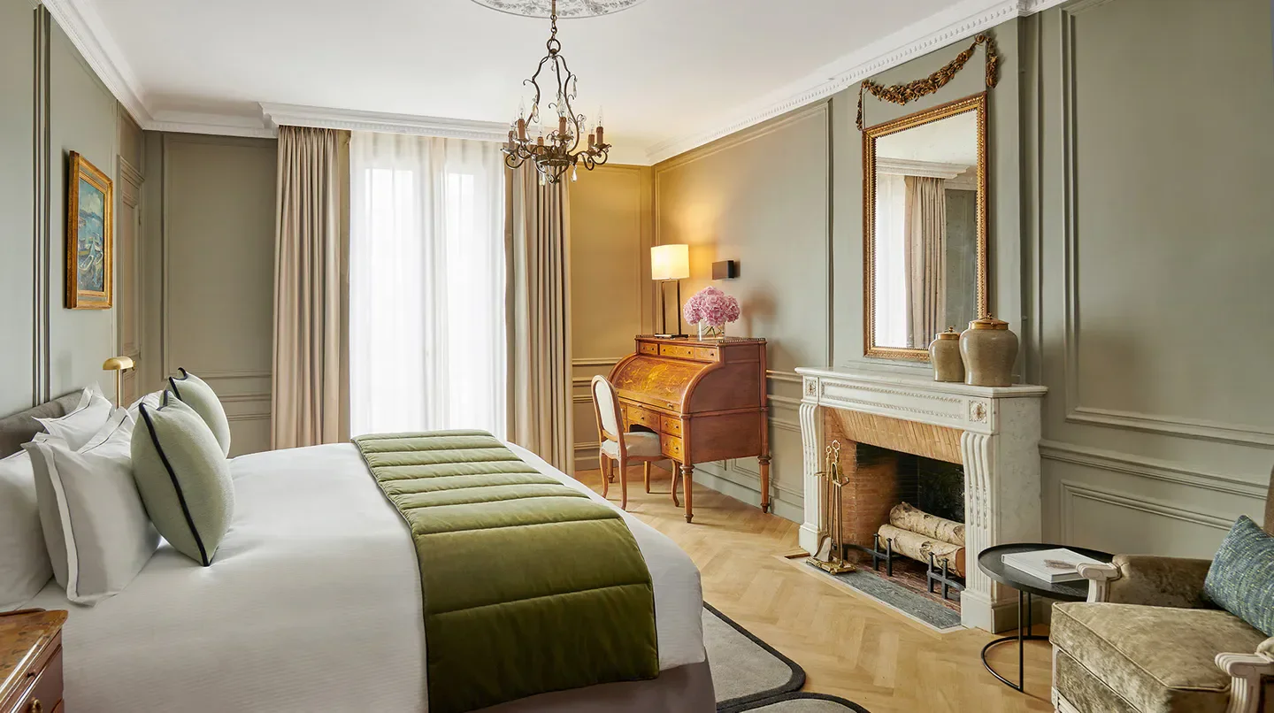 Elegant bedroom at Hotel Lancaster in Paris, featuring fireplace and stylish decor.
