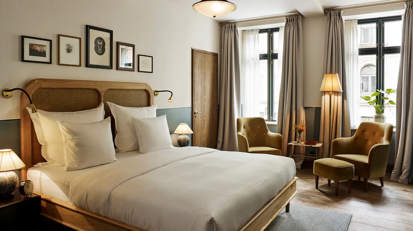 Cozy bedroom at Hotel Sanders in Copenhagen, featuring stylish decor and comfortable furnishings.