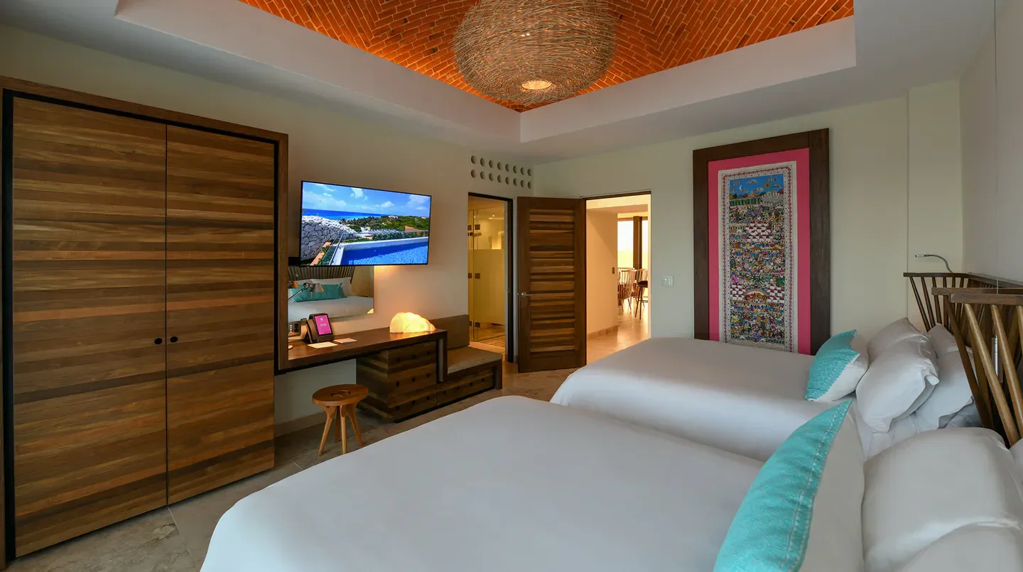 Stylish bedroom at Hotel Xcaret Mexico in Playa del Carmen, featuring comfortable beds and decor.