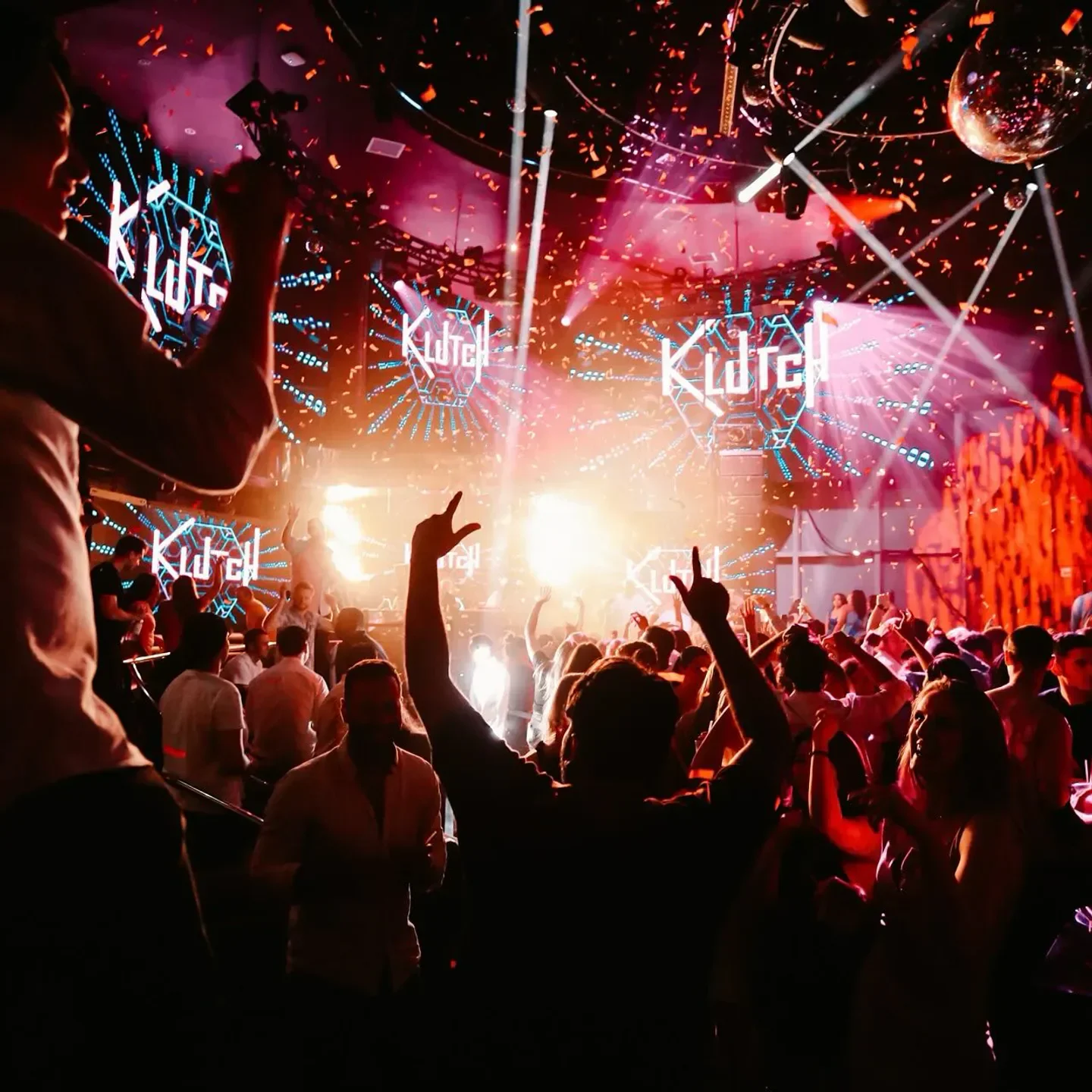 Energetic crowd dancing inside HQ2 Nightclub in Atlantic City with confetti and lights.