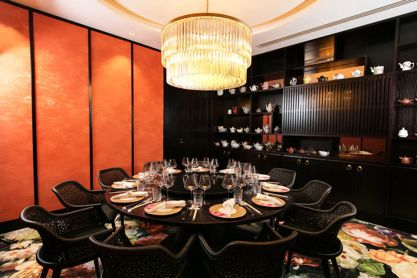 Elegant dining room at Huami restaurant in Auckland, with a large round table and chandelier.
