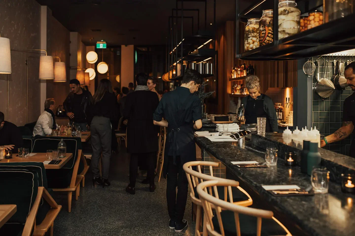 Elegant dining interior at Hugo's Bistro in Auckland, featuring a stylish bar and patrons.