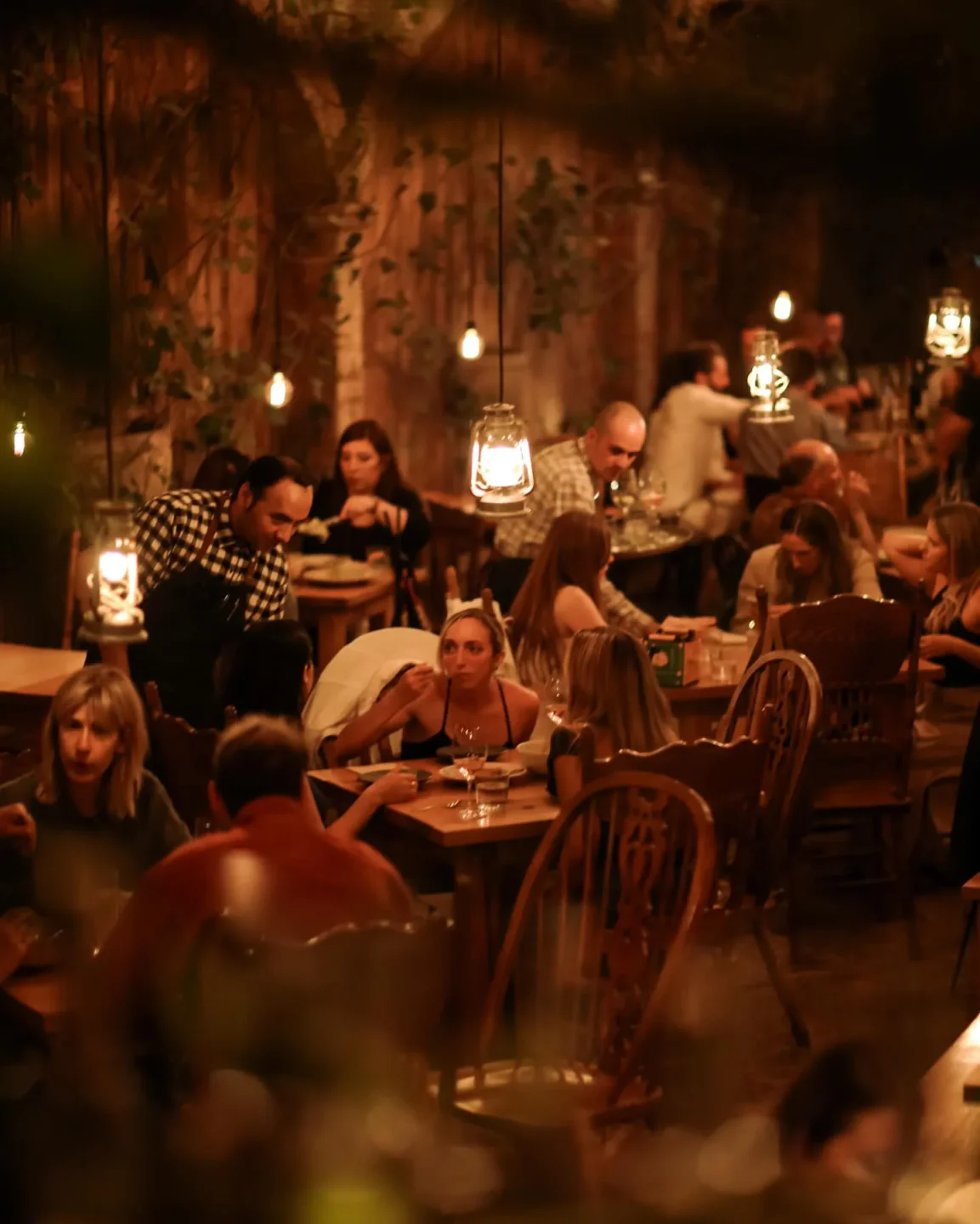 Cozy interior of Huset restaurant in Mexico City with diners enjoying a meal under warm lighting