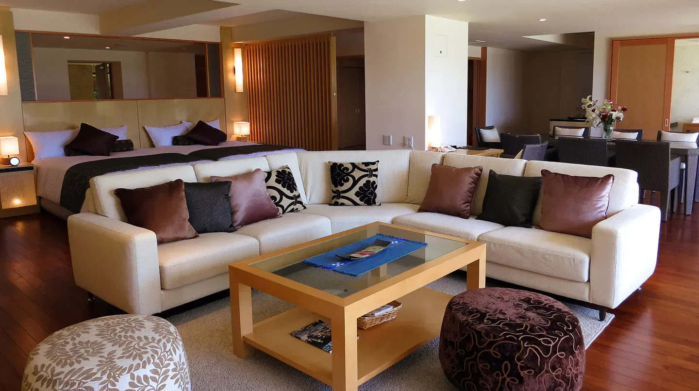 Spacious living area and bedroom at Hyakuna Garan hotel in Okinawa, featuring modern design.